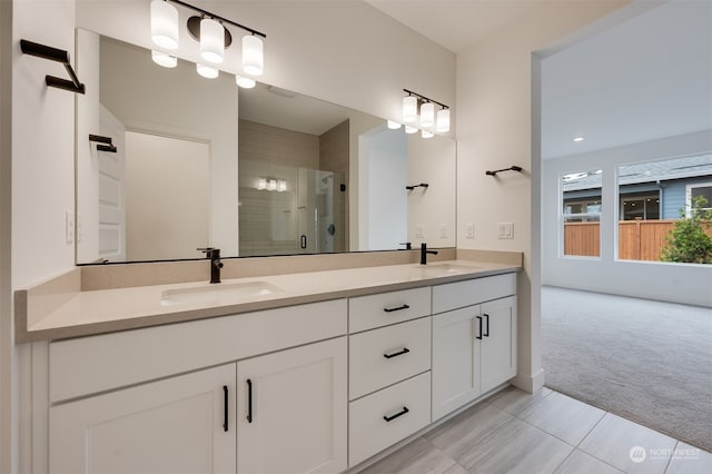 bathroom featuring a shower with door, vanity, and tile patterned flooring