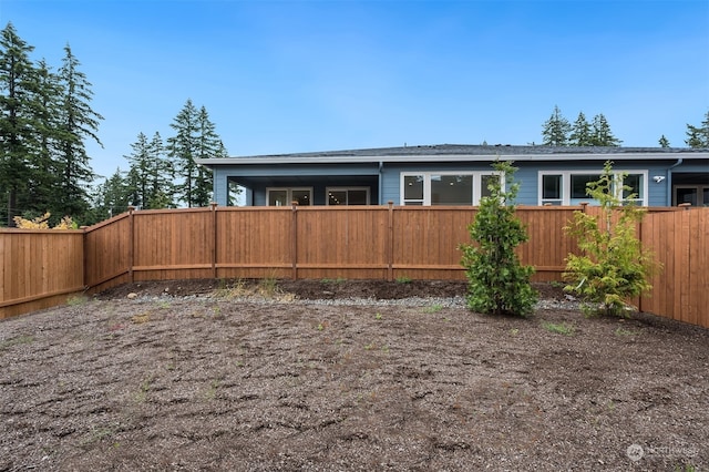 back of house with a fenced backyard