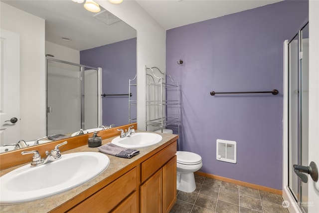 bathroom featuring a shower with door, vanity, tile patterned flooring, toilet, and heating unit