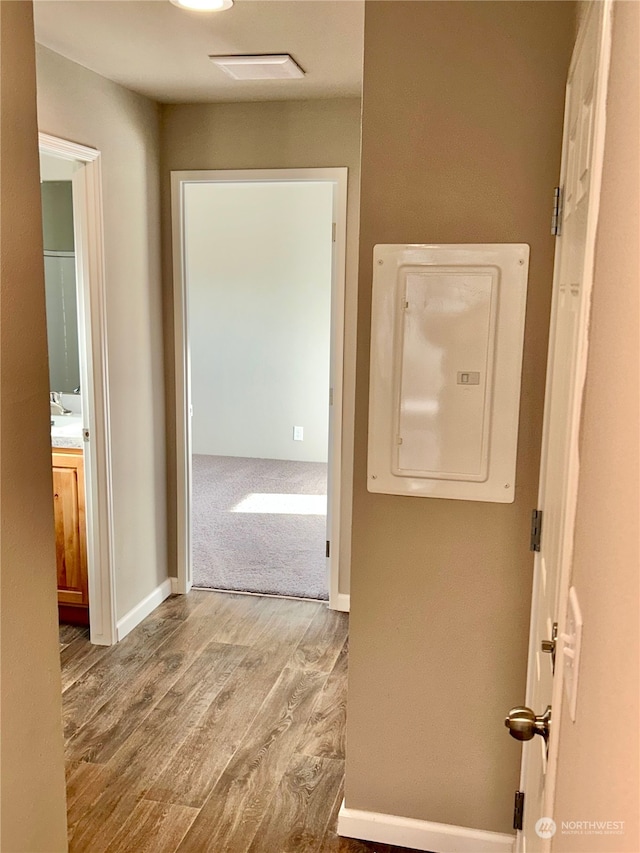 hall featuring light wood-type flooring and electric panel