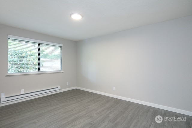 unfurnished room featuring a baseboard heating unit and dark wood-type flooring