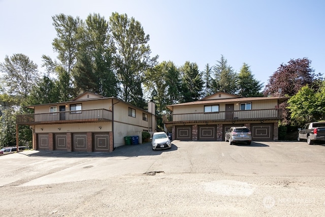 front facade with a balcony and a garage