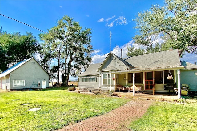 rear view of property featuring a lawn