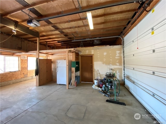 garage featuring white fridge and a garage door opener