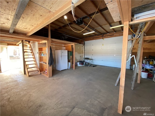 garage with a garage door opener and white fridge