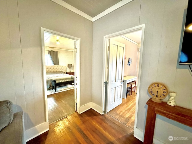 hallway featuring ornamental molding and hardwood / wood-style floors