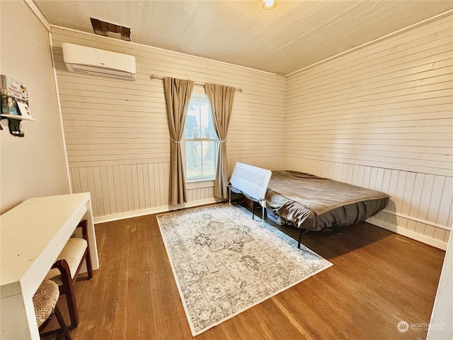 bedroom with dark hardwood / wood-style floors, a wall unit AC, and wooden walls