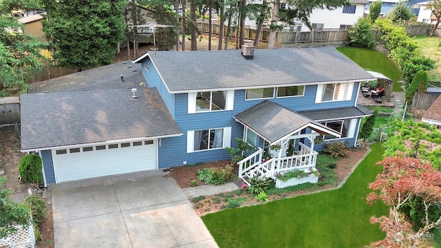 view of front of property featuring a garage, a front yard, and a porch