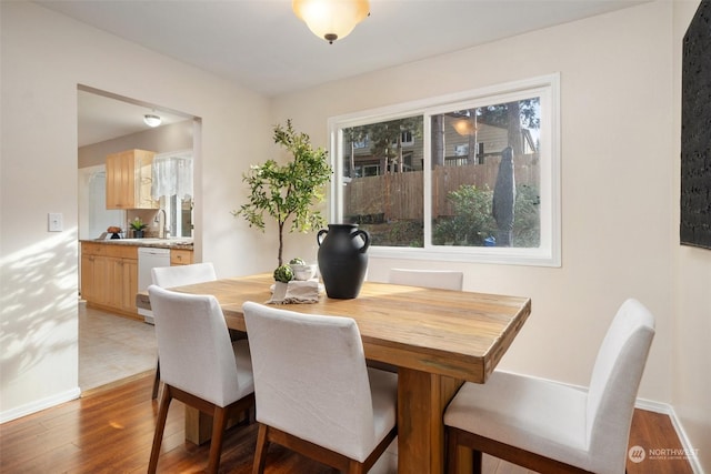 dining room with wood-type flooring and a healthy amount of sunlight