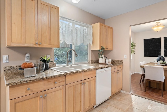 kitchen with light tile patterned flooring, white dishwasher, sink, and light brown cabinets