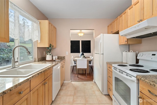 kitchen featuring sink, light stone counters, light brown cabinets, light tile patterned floors, and white appliances