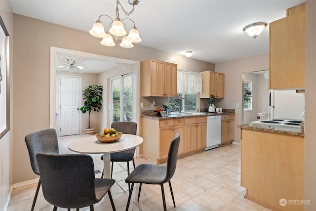 kitchen with sink, light brown cabinets, white appliances, and decorative light fixtures