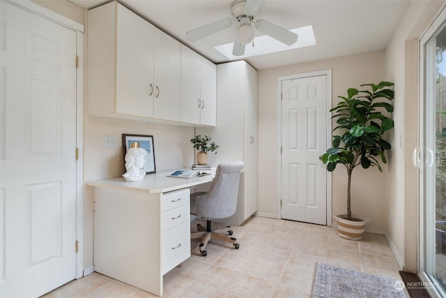 office space featuring a skylight, built in desk, and ceiling fan