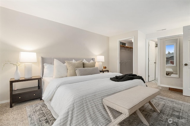 carpeted bedroom with a spacious closet and a closet