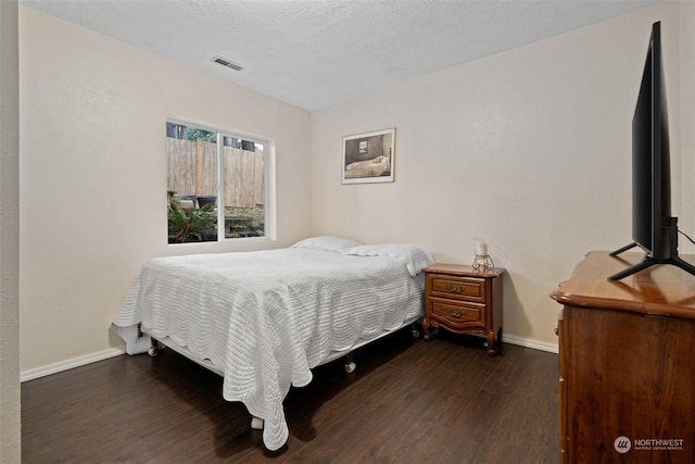 bedroom with dark wood-type flooring and a textured ceiling