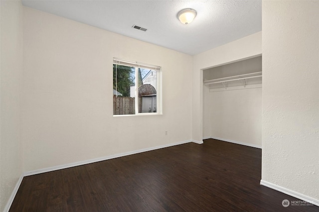 unfurnished bedroom with a closet and dark hardwood / wood-style floors