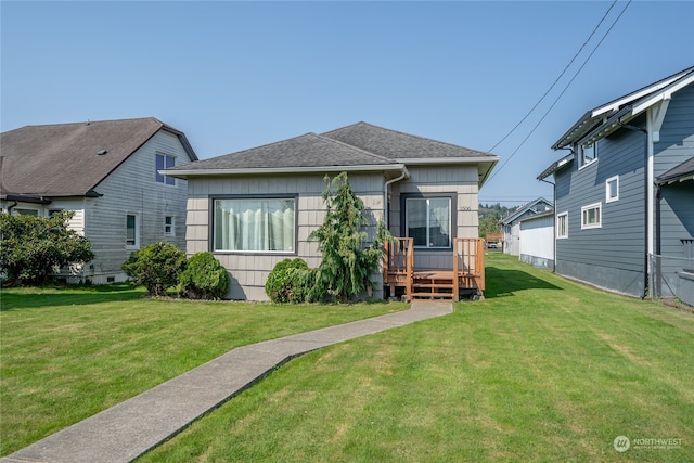 bungalow featuring a front lawn and a deck