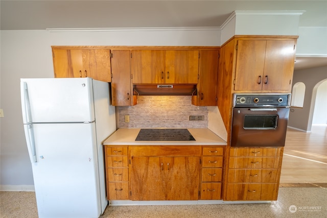 kitchen with ornamental molding, black appliances, and decorative backsplash