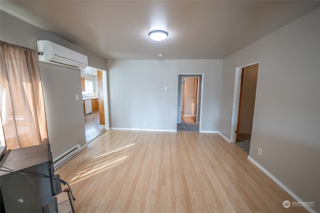 interior space featuring light wood-type flooring, a baseboard heating unit, and a wall unit AC