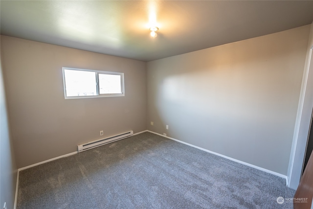 spare room with a baseboard heating unit and carpet