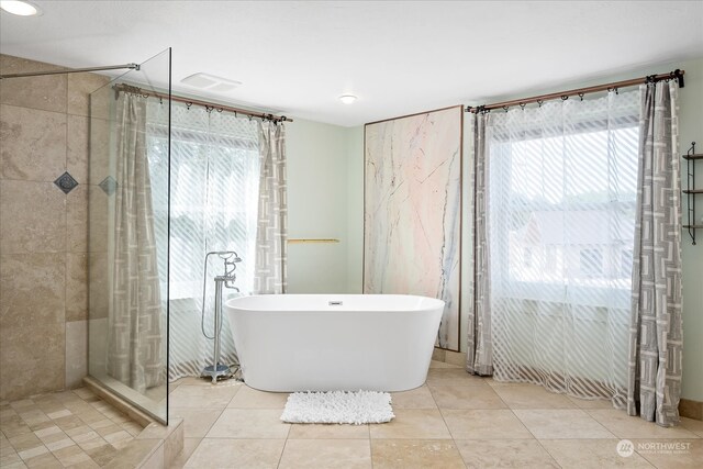 bathroom with tile patterned flooring and shower with separate bathtub