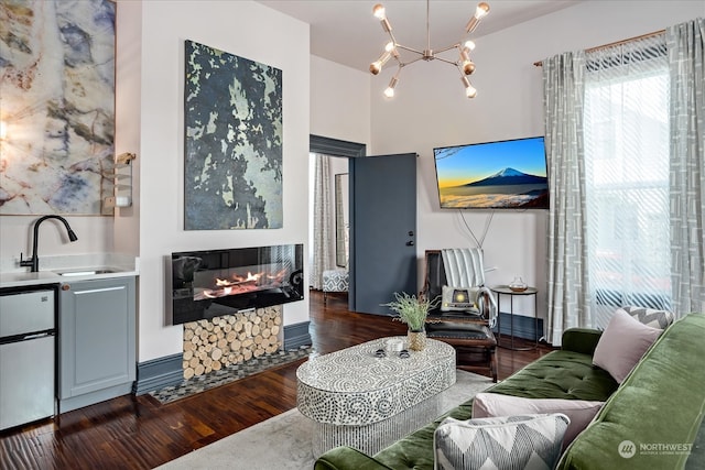 living room with dark hardwood / wood-style floors, a notable chandelier, and sink