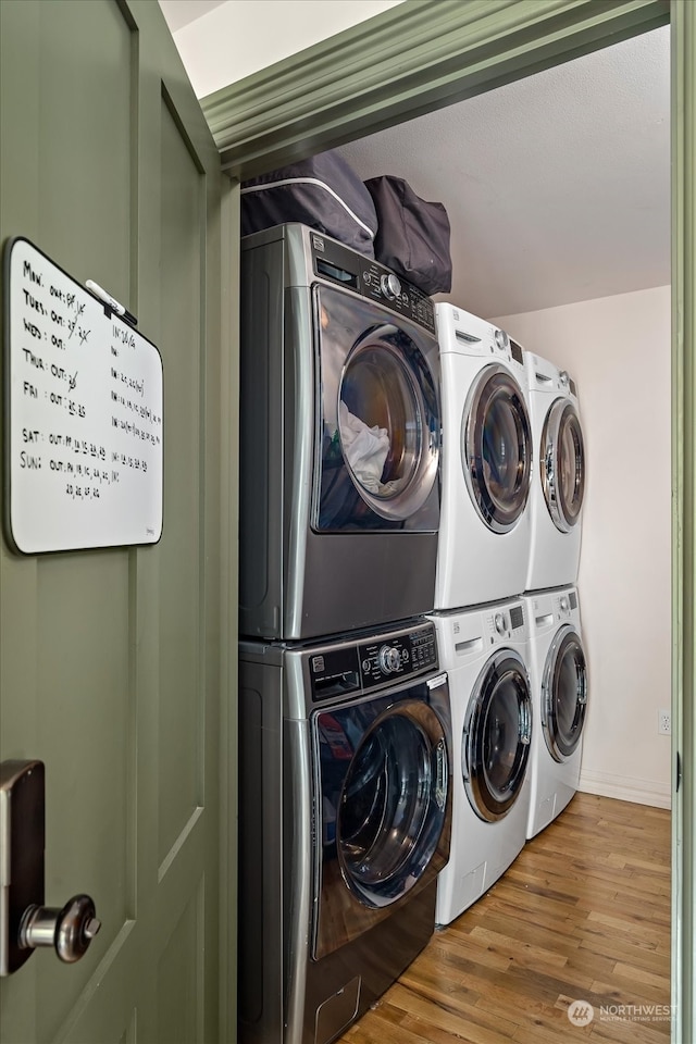 laundry room with wood-type flooring, washer and dryer, and stacked washing maching and dryer