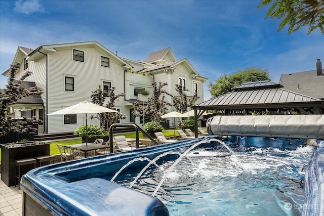 view of swimming pool featuring a gazebo and a hot tub