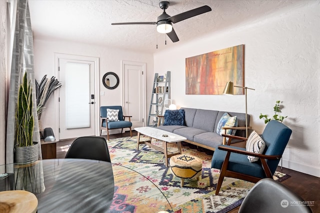 living room featuring ceiling fan, hardwood / wood-style flooring, and a textured ceiling