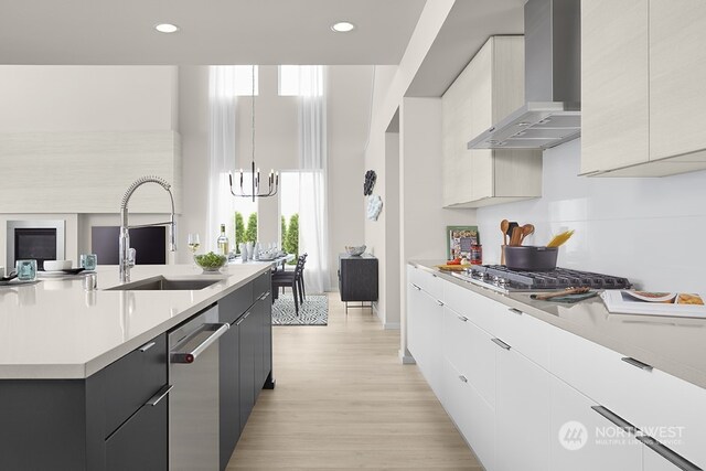 kitchen featuring modern cabinets, a sink, stainless steel appliances, wall chimney exhaust hood, and light countertops