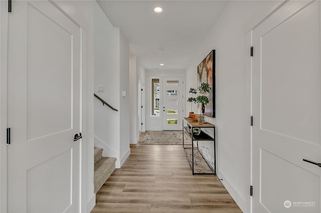 hall with stairway, recessed lighting, baseboards, and light wood-style floors