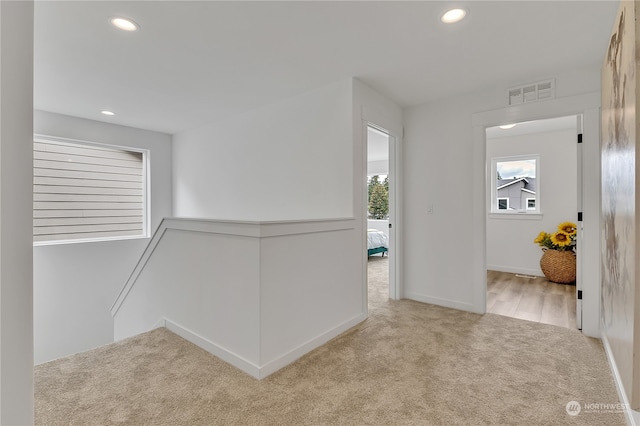 hallway featuring light colored carpet