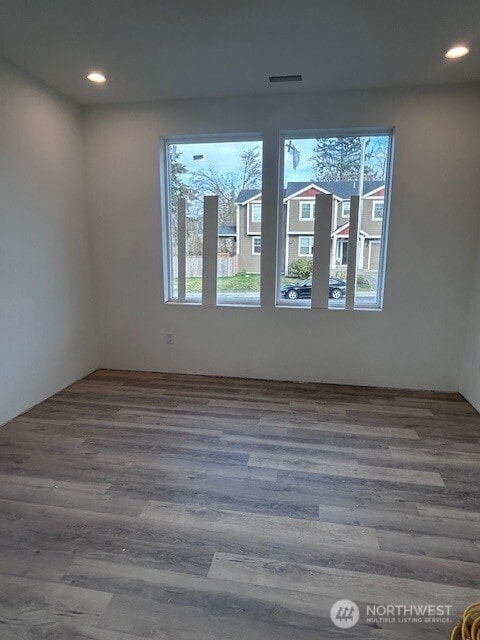 unfurnished room with recessed lighting, wood finished floors, and visible vents