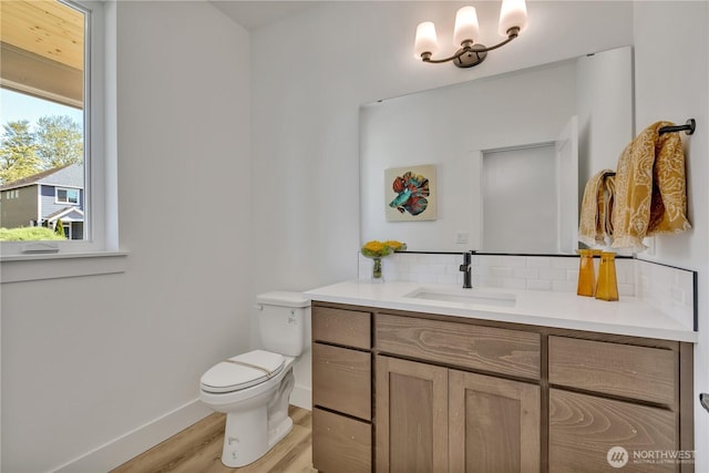16212 76th Avenue Ct E, Puyallup, WA 98375 - bathroom with backsplash, wood finished floors, toilet, vanity, and baseboards