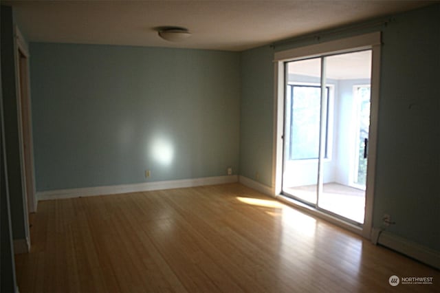 spare room with light hardwood / wood-style floors and baseboard heating