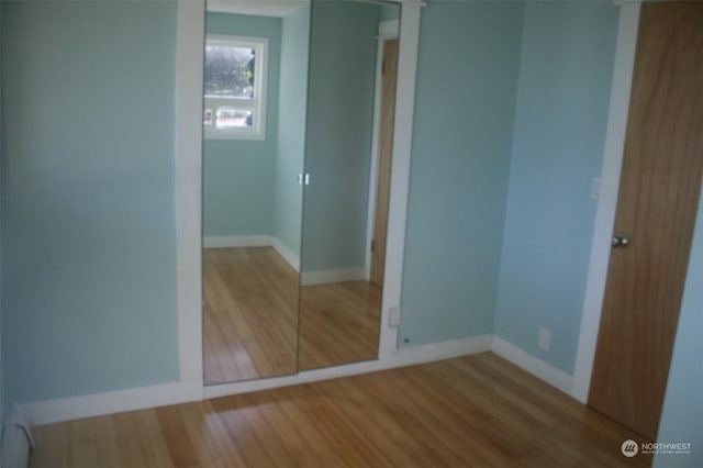 unfurnished bedroom featuring hardwood / wood-style floors and a closet