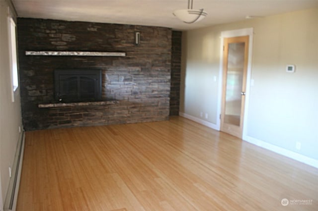 unfurnished living room with light wood-type flooring and baseboard heating