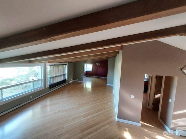 spare room featuring beamed ceiling and light hardwood / wood-style floors