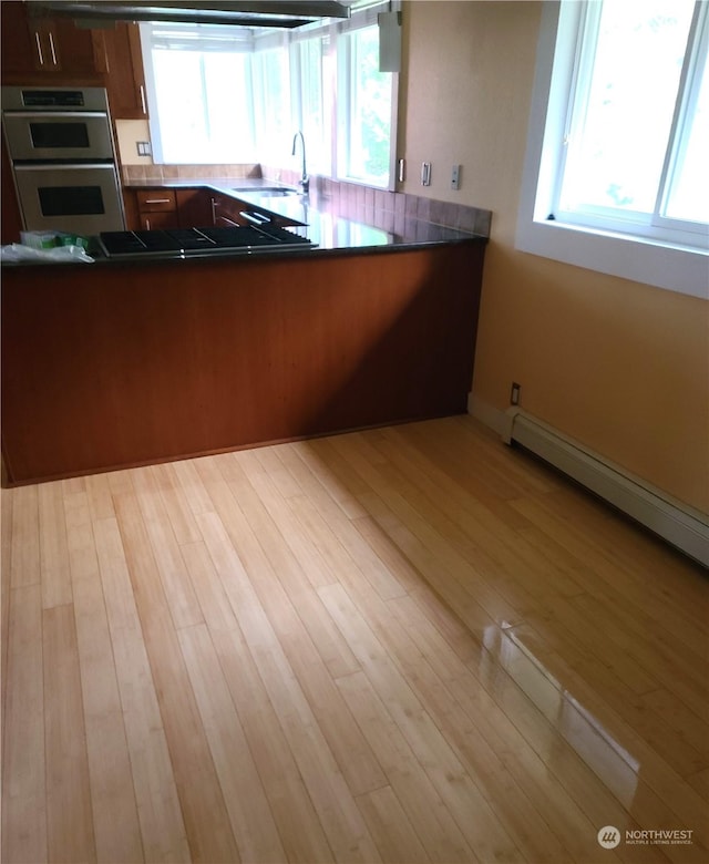 kitchen with kitchen peninsula, sink, a healthy amount of sunlight, and appliances with stainless steel finishes