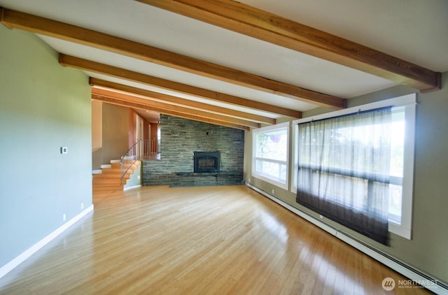 unfurnished living room with stairway, baseboard heating, wood finished floors, beamed ceiling, and baseboards