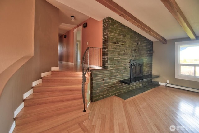 staircase featuring baseboard heating, vaulted ceiling with beams, baseboards, and wood finished floors