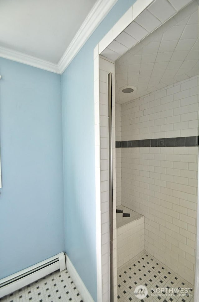 bathroom with a baseboard heating unit, a stall shower, ornamental molding, tile patterned flooring, and baseboards