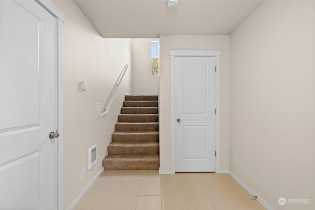 staircase featuring tile patterned flooring