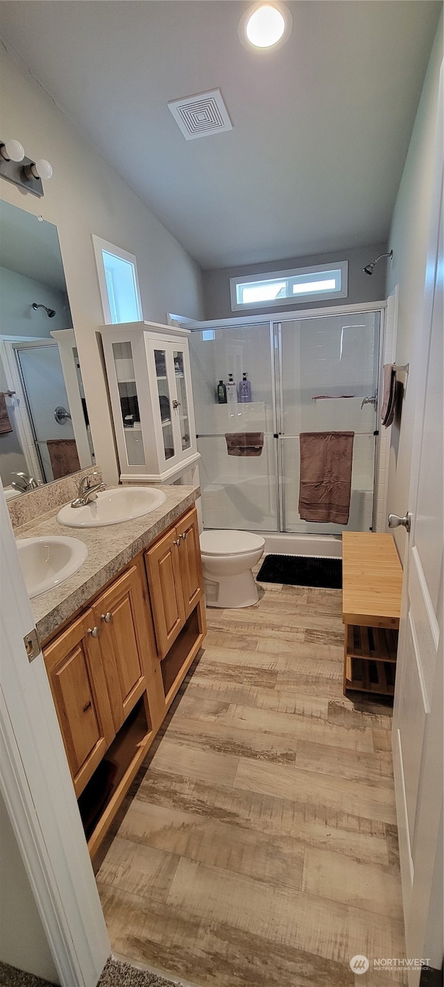 bathroom with a shower with shower door, toilet, hardwood / wood-style flooring, and vanity