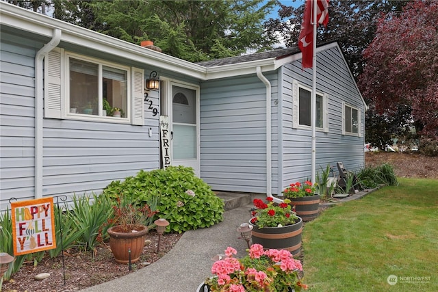 doorway to property with a lawn