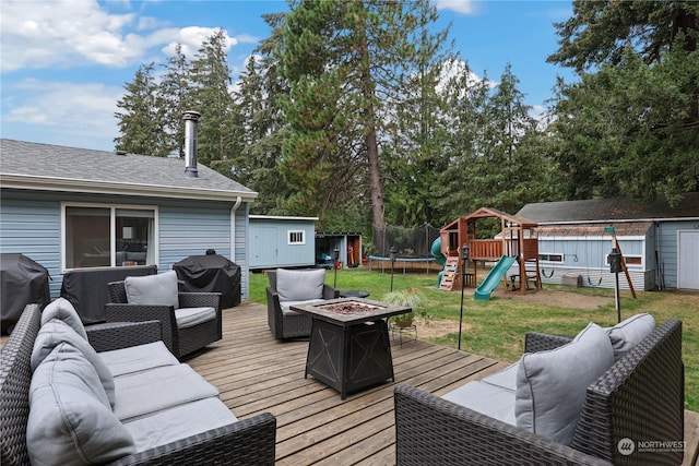 wooden terrace featuring an outdoor living space with a fire pit, a storage shed, a playground, and a trampoline