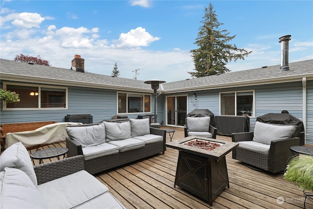 wooden deck with an outdoor living space with a fire pit