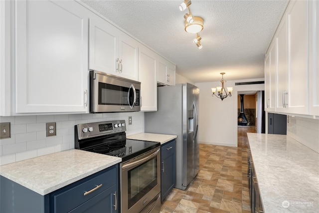 kitchen with light countertops, white cabinets, blue cabinets, and stainless steel appliances