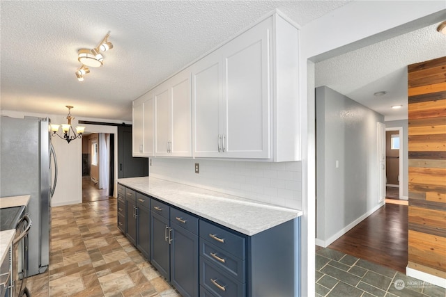 kitchen with white cabinetry, a barn door, stainless steel appliances, light countertops, and decorative backsplash