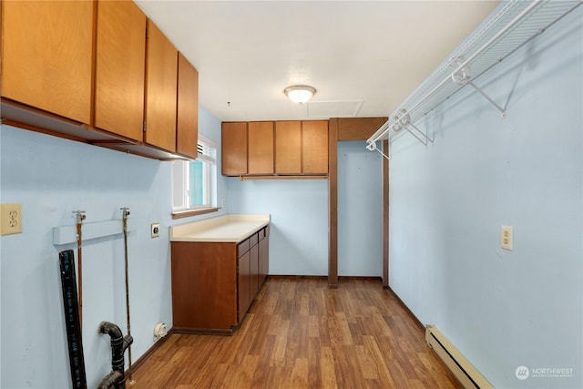 laundry room featuring washer hookup, wood finished floors, cabinet space, and a baseboard radiator